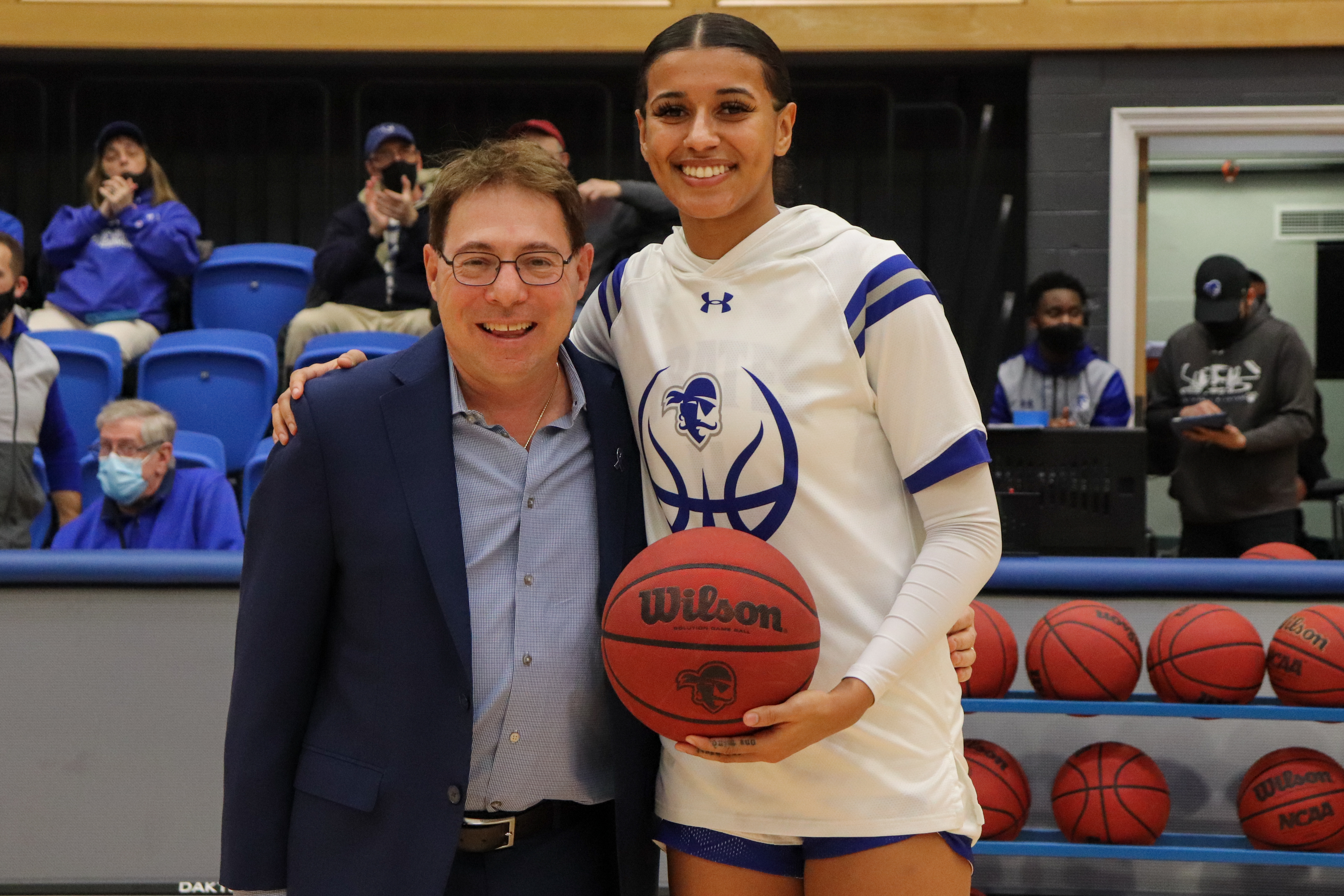 Seton Hall head coach Tony Bozzella and Andra Espinoza-Hunter pose for a photo in honor of her 1,000-point achievement.