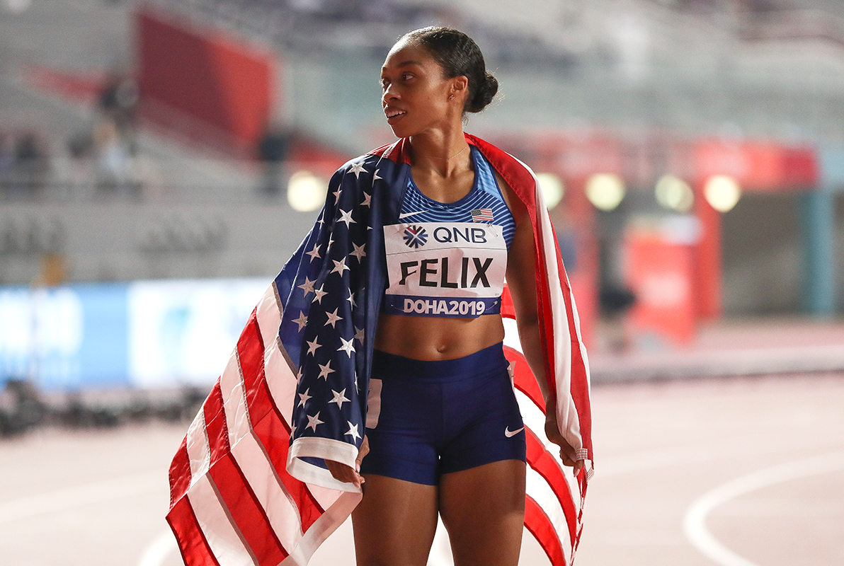 Allyson Felix has an American flag on her shoulders after running in a track race.