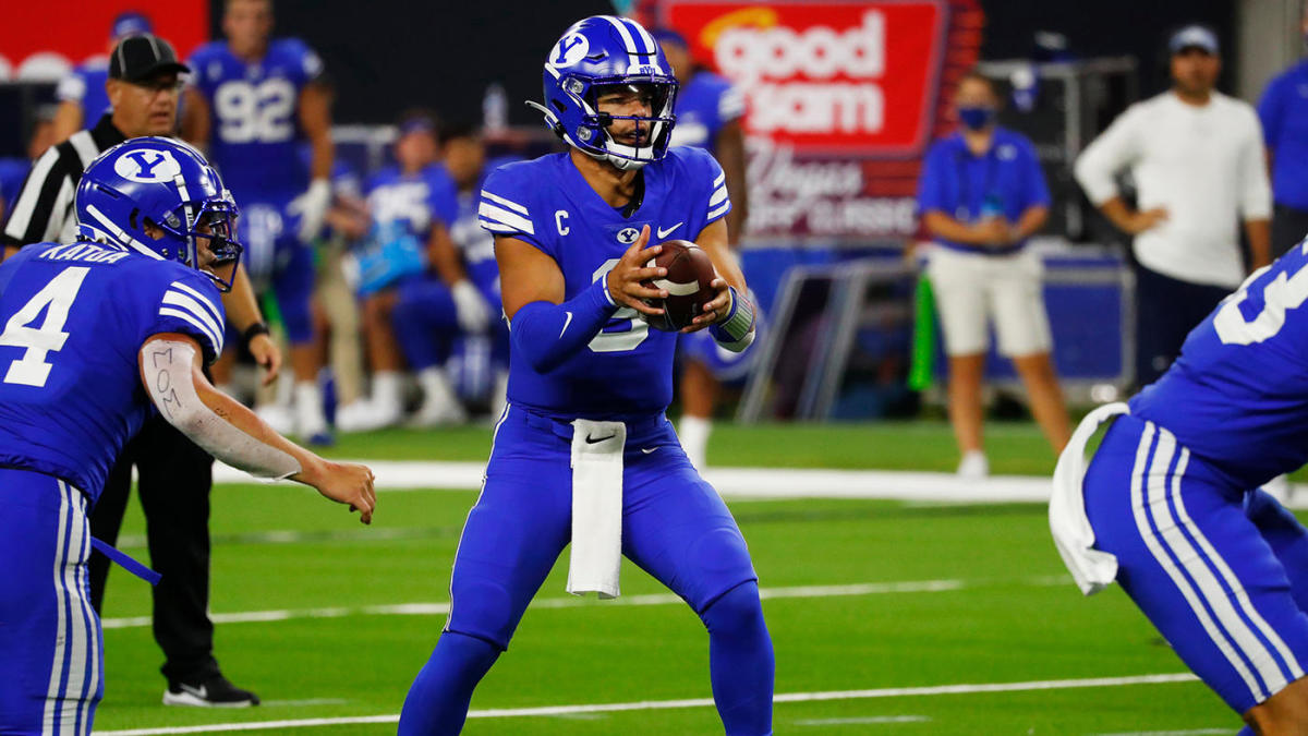 A BYU QB hands the ball off during a college football game.