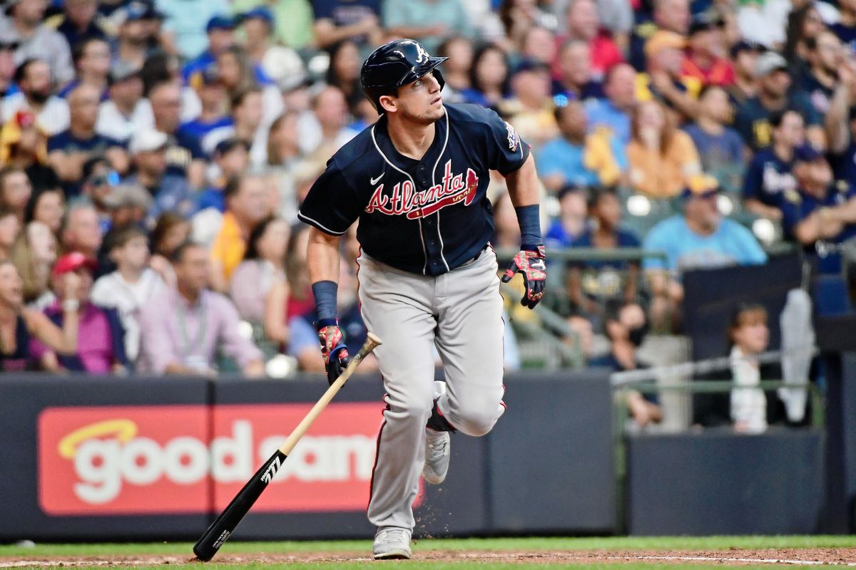 A Braves player runs and drops his bat during a MLB game.