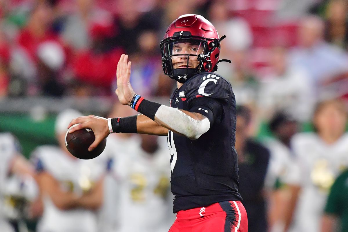 A Cincinnati quarterback looks to throw during a college football game