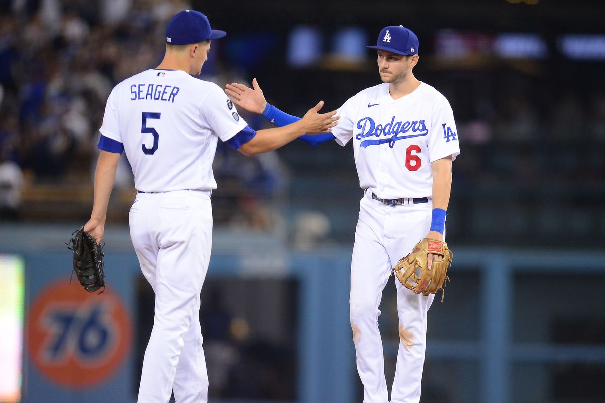 Two Los Angeles Dodgers teammates high-five each other during a MLB game.