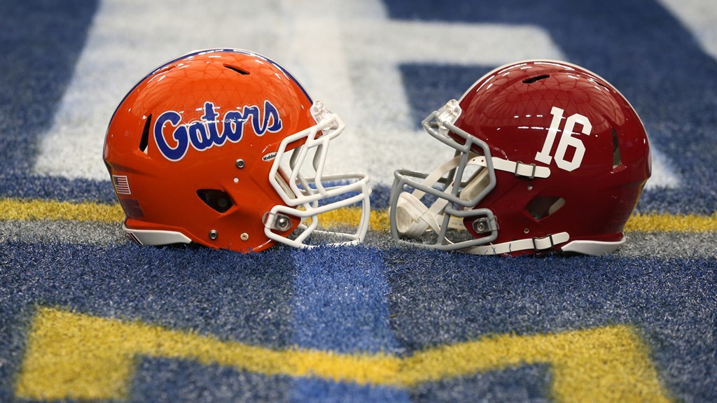 The Florida and Alabama football helmets are on the field of a college football game.