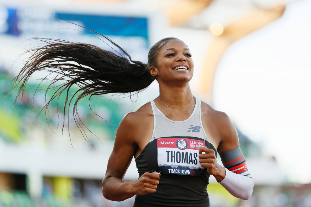 Team USA's Gabby Thomas smiles as she runs in a track race.