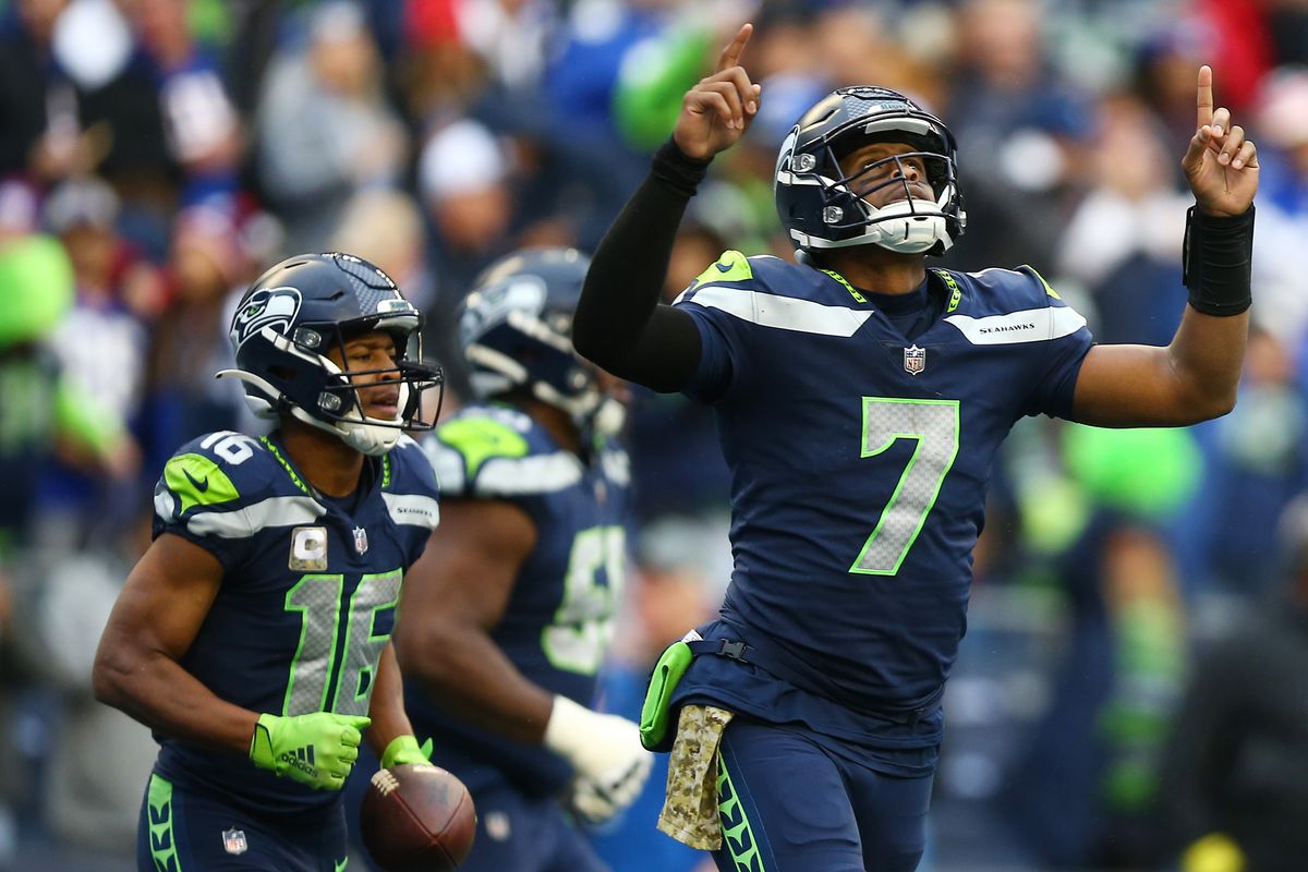 Geno Smith points to the sky after firing a touchdown to Tyler Lockett.