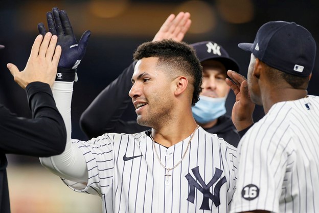 New York Yankees' Gleyber Torres high-fives teammates in the dugout during a MLB game.