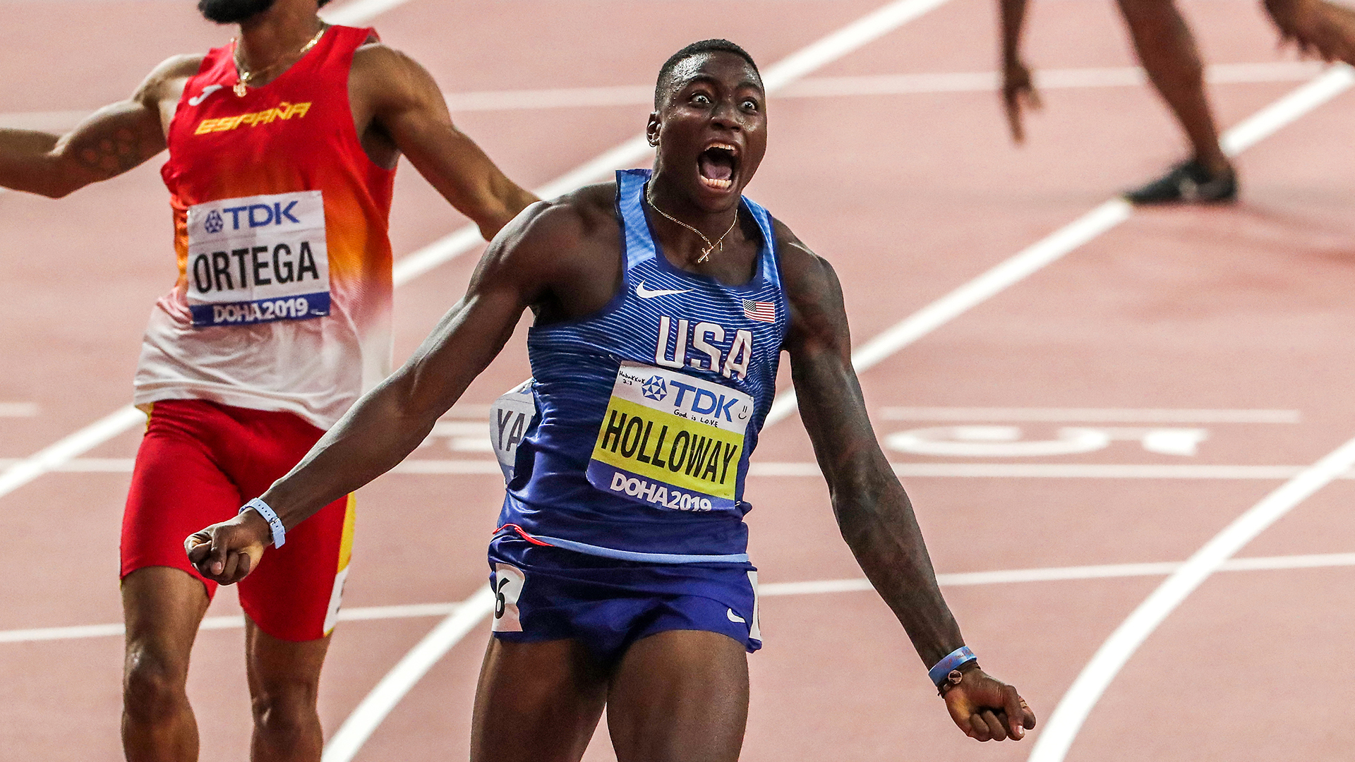 Grant Holloway celebrates with emotion after winning a track race for Team USA.