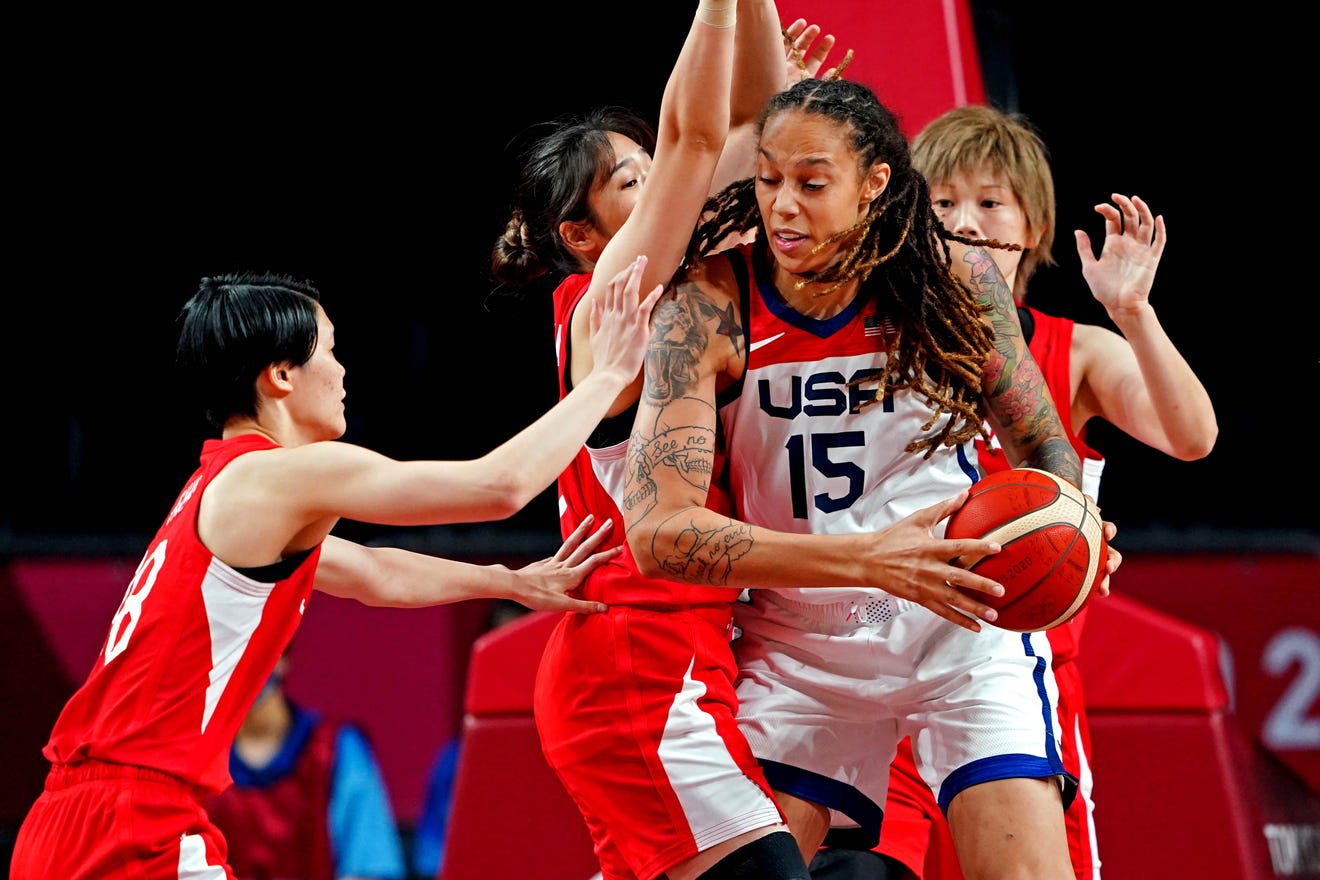 Brittney Griner tries to score against Japan's defenders in the Tokyo Olympic Games.