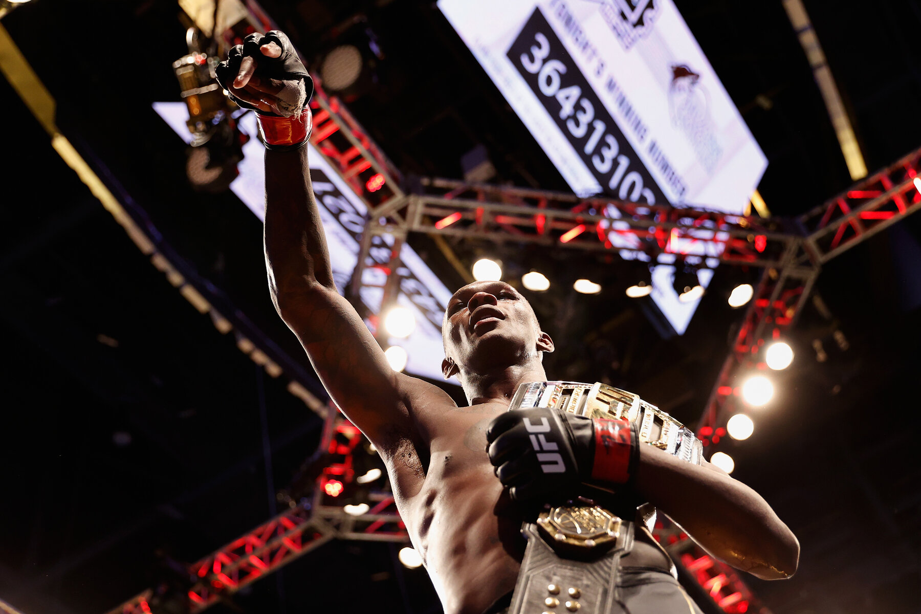 Israel Adesanya walks off with his title belt.