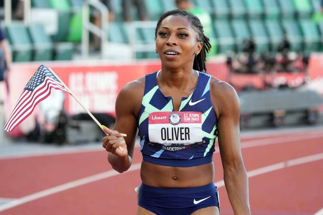 Team USA's Javianne Oliver holds an American flag after running in a race.