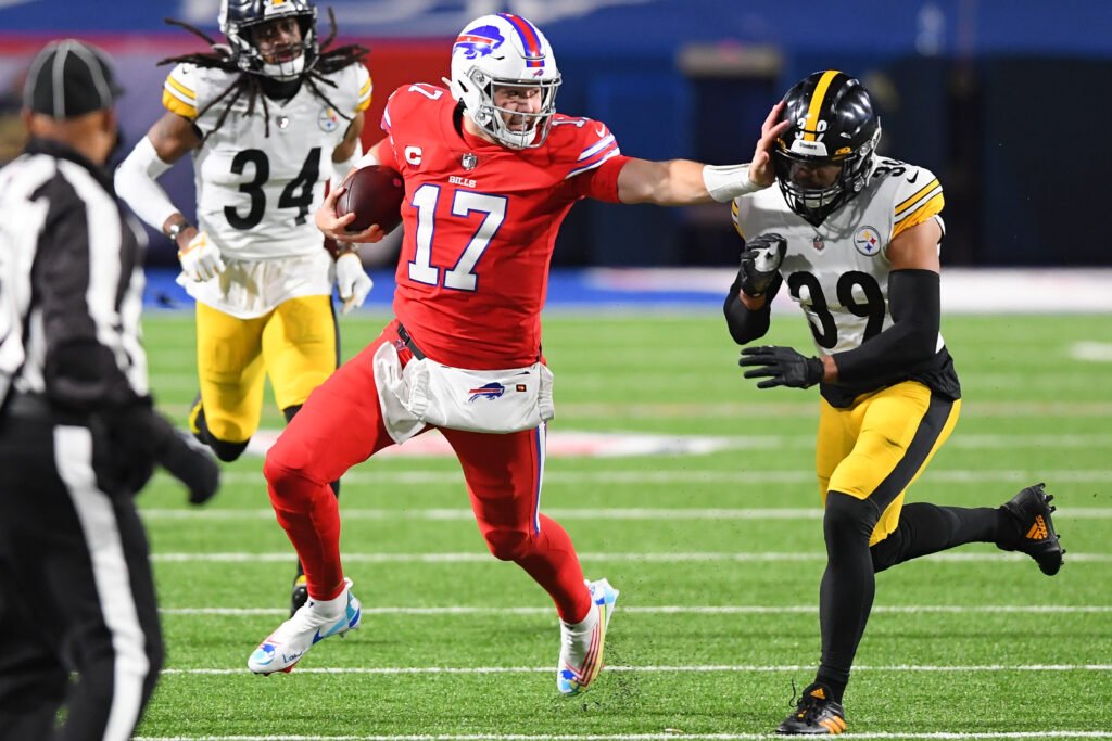 Buffalo's Josh Allen stiff arms a Steelers player during a NFL game.