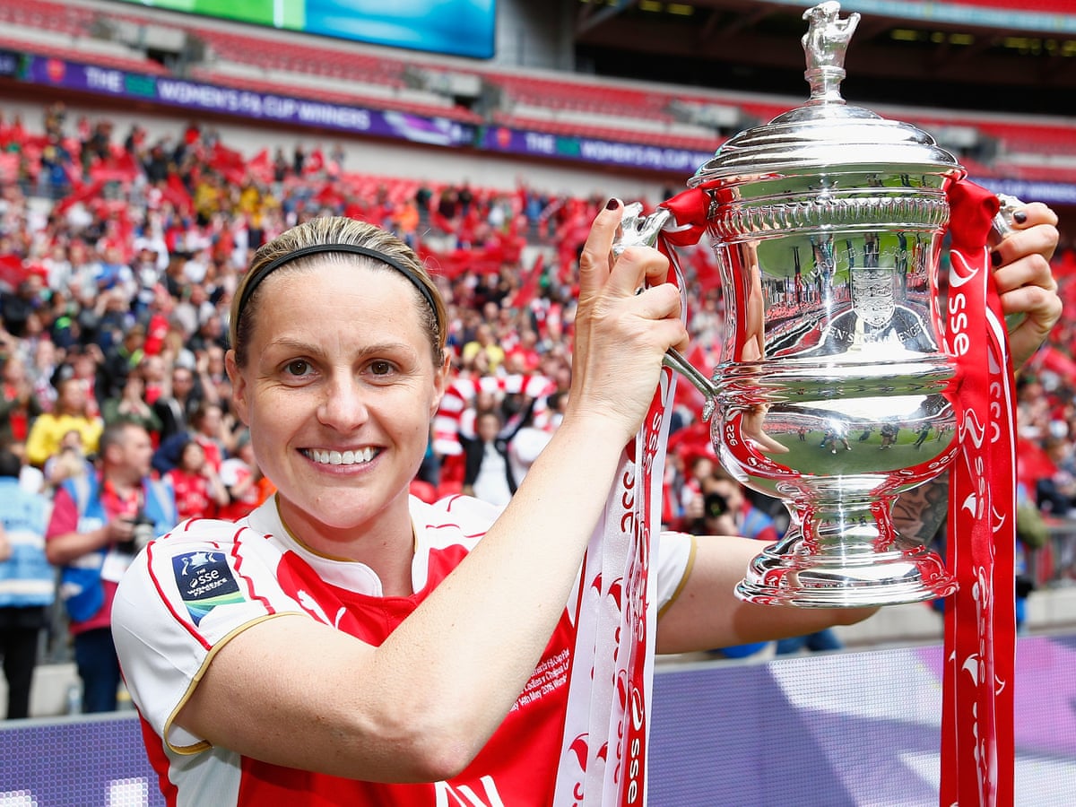 Seton Hall's former star Kelly Smith holds up a trophy after a game.