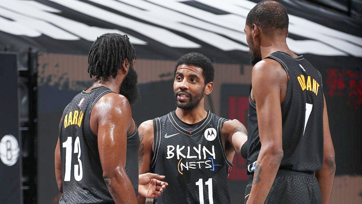 Brooklyn's Kyrie Irving, James Harden, and Kevin Durant talk on the court during a Nets game.