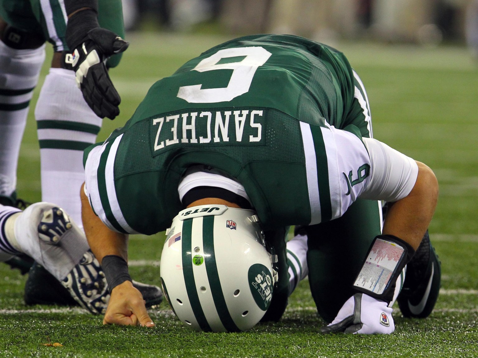 New York Jets quarterback Mark Sanchez sits on the ground during a NFL Thanksgiving game.