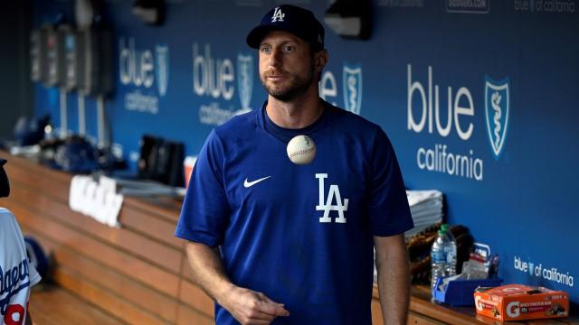 Max Scherzer stands in the Dodgers dugout during a MLB game.