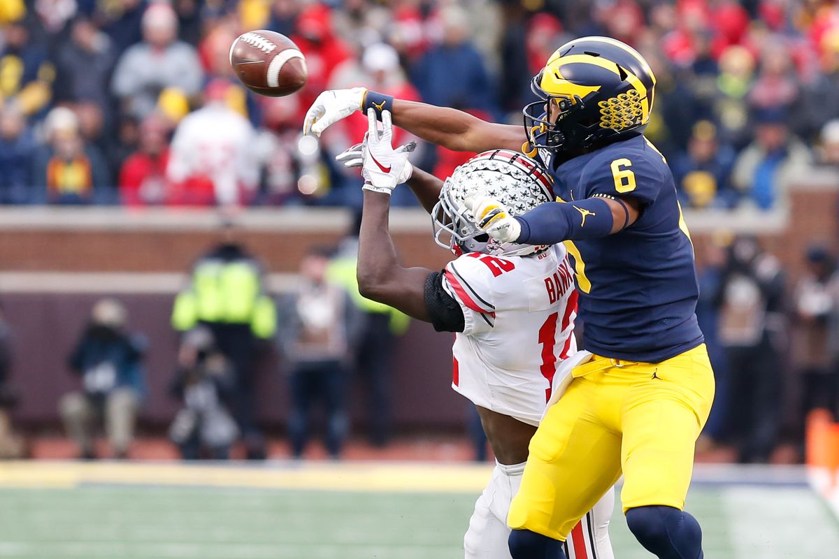 A Michigan wide receiver catches the ball over an Ohio State defender during a college football game.