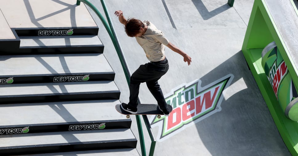 An Olympic skateboarder skates on a course to try and win the competition.