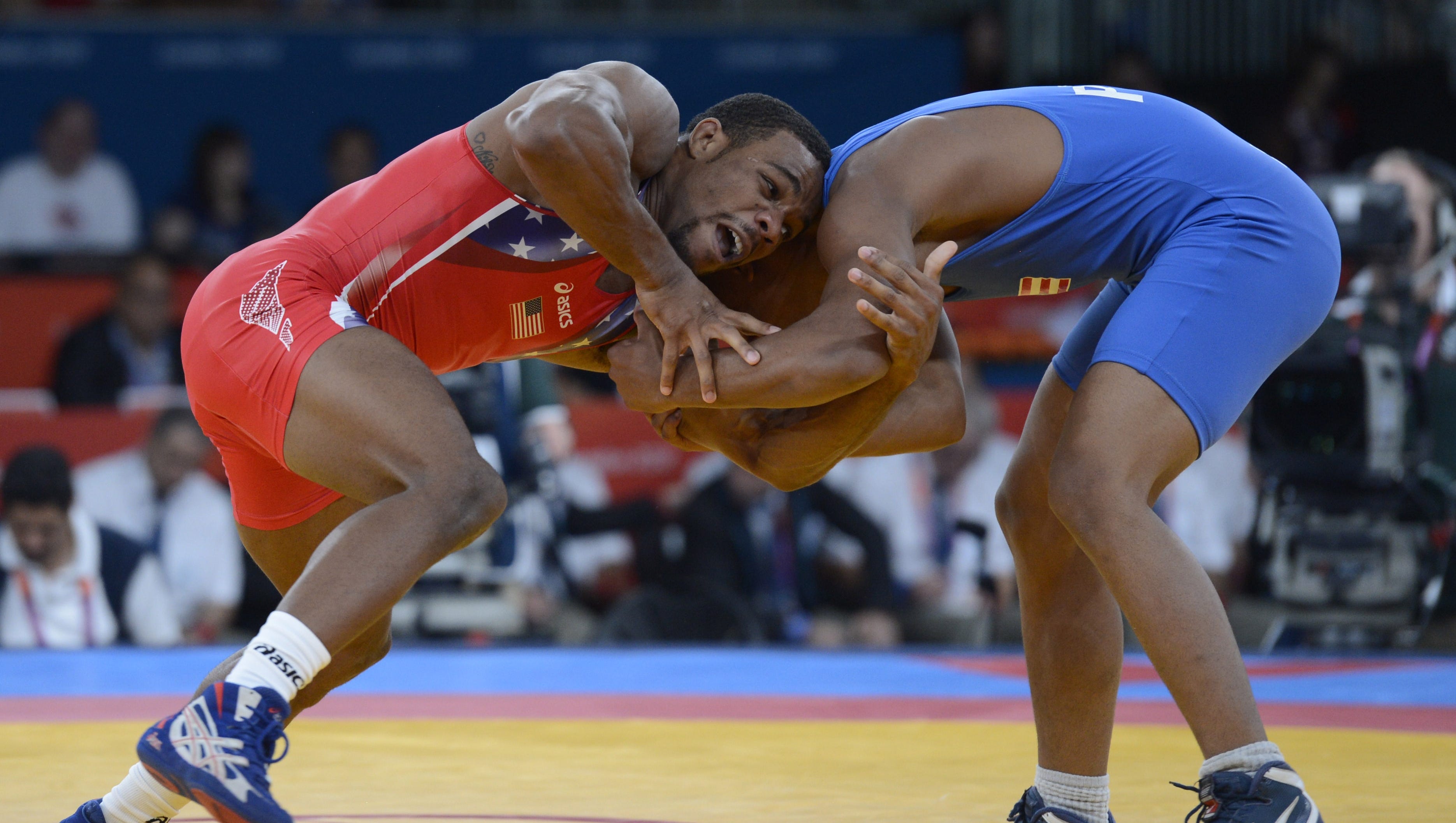 Two wrestlers compete for a gold medal in the Olympic Games.