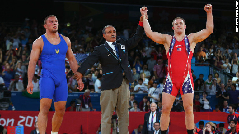 Two wrestlers stand with the official after a hard-fought match.
