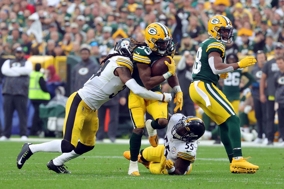 A Green Bay Packers running back runs against the Pittsburgh Steelers defense.