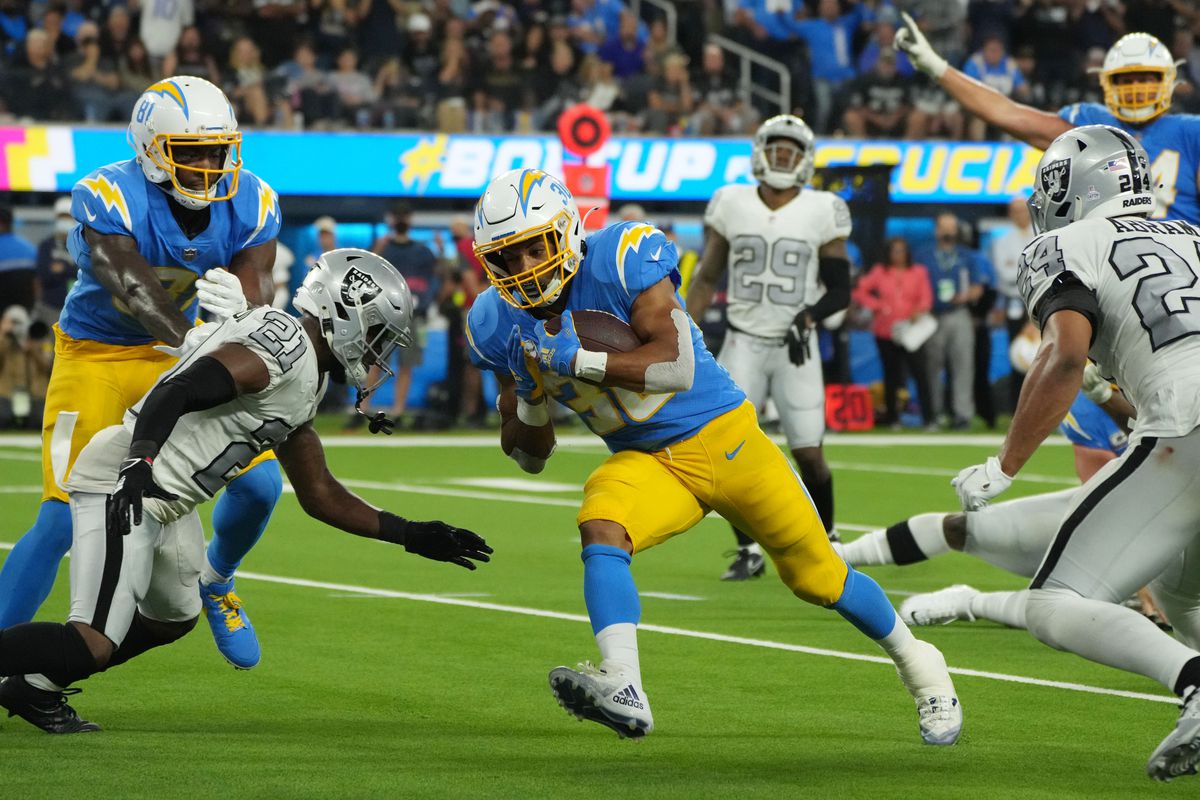 A Chargers running back looks to score a touchdown during an NFL game against the Las Vegas Raiders.