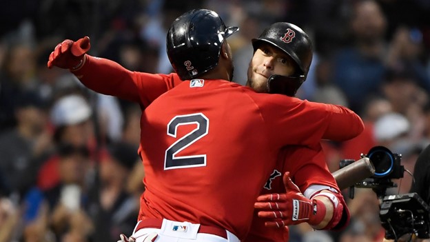 Two Boston Red Sox players hug during a MLB game.