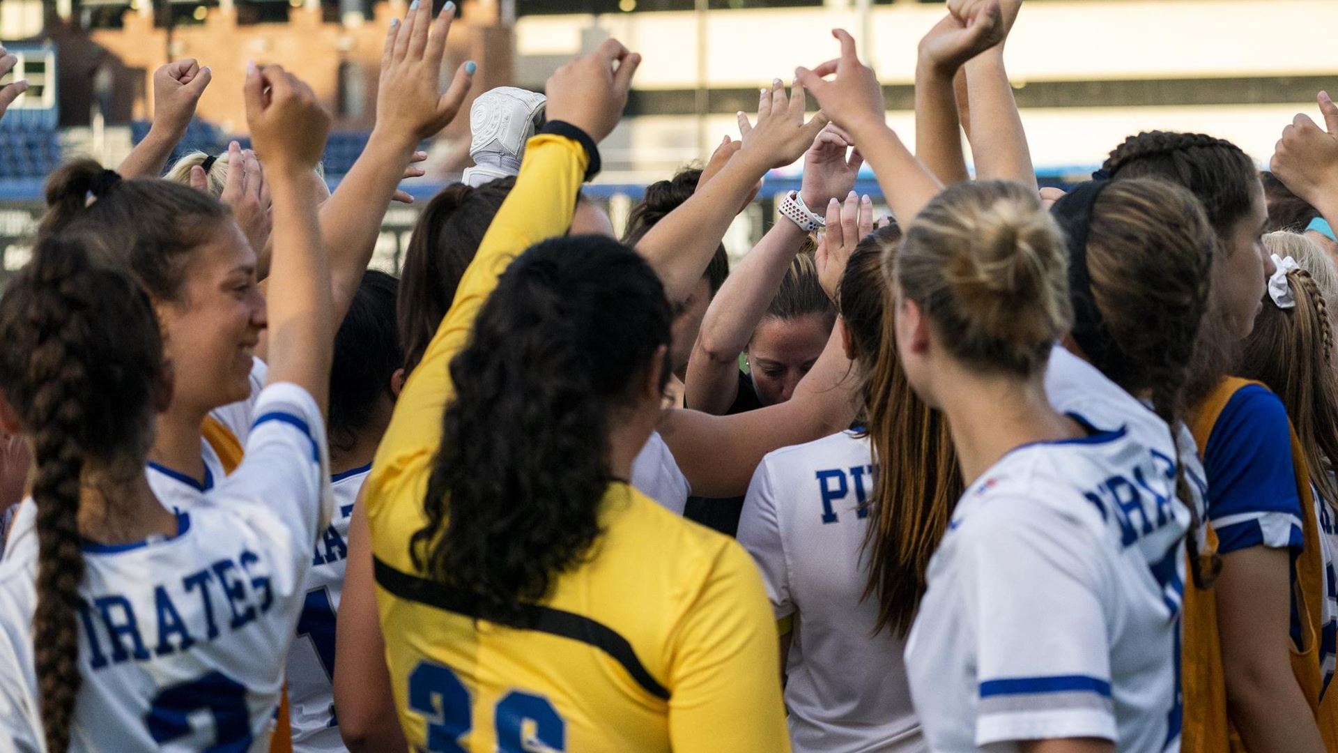 The Seton Hall women's soccer team stands in a huddle before a game.