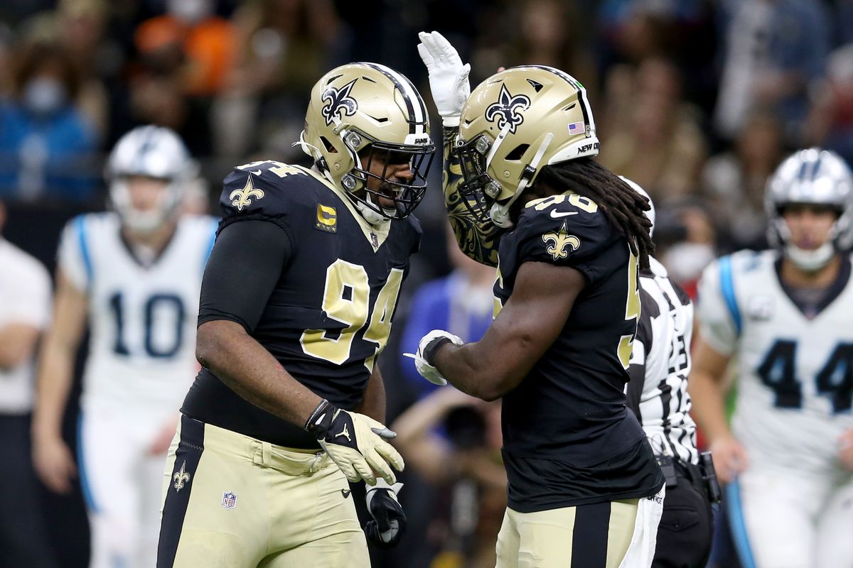 Two New Orleans players celebrate on the field during a Saints game.