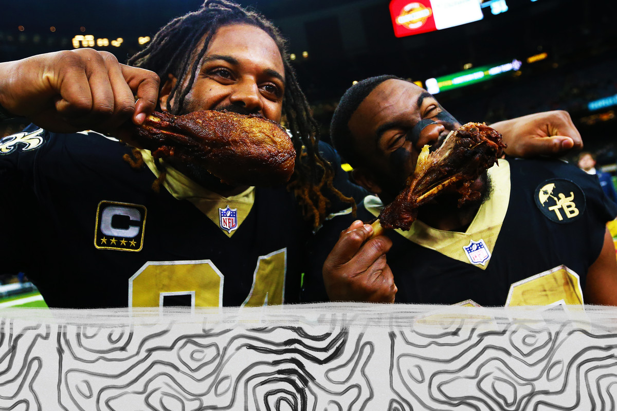 Two New Orleans Saints players eat turkey after a NFL game.