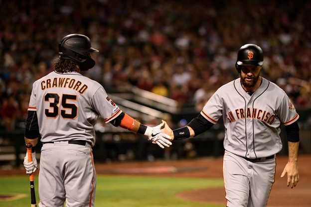 Two San Francisco Giants high-five during a MLB game.