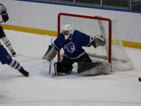 A Seton Hall men's hockey goalie attempts to stop a shot in a home game.