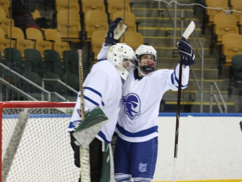 A Seton Hall goalie and his teammate in net celebrate after winning a game.
