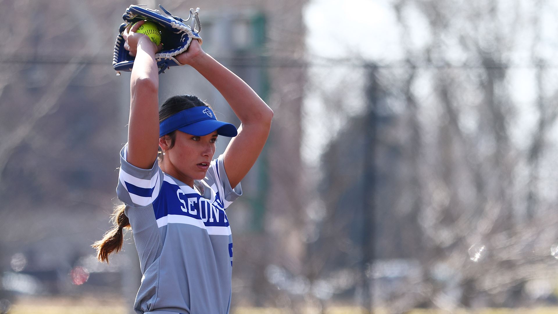 A Seton Hall softball pitcher looks to pitch during a game.