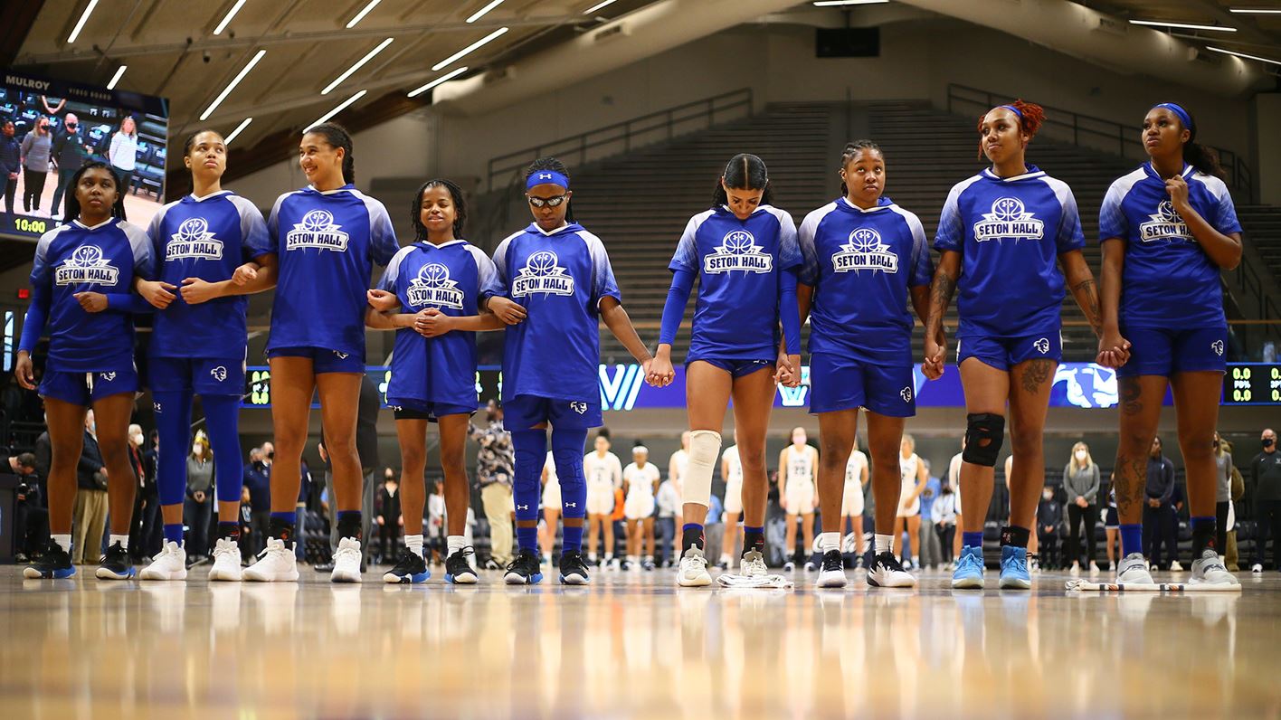The Seton Hall women's basketball team stands together on the court against Villanova on the road.