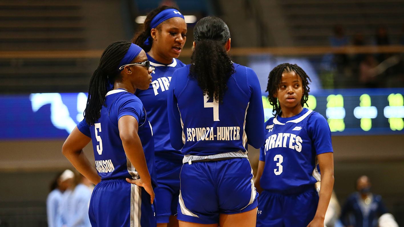Four members of the Seton Hall women's basketball team huddle together during a game.