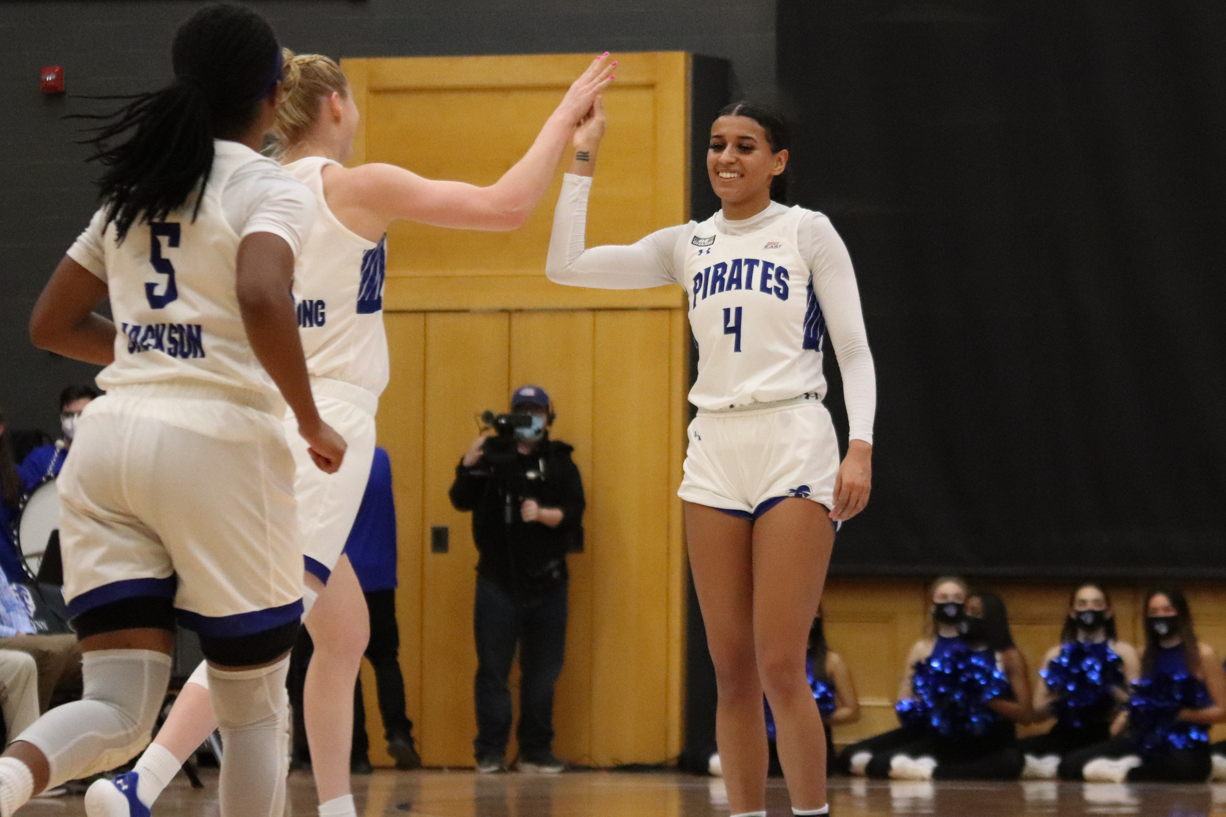 Seton Hall women's basketball teammates celebrate on the court during a home game.
