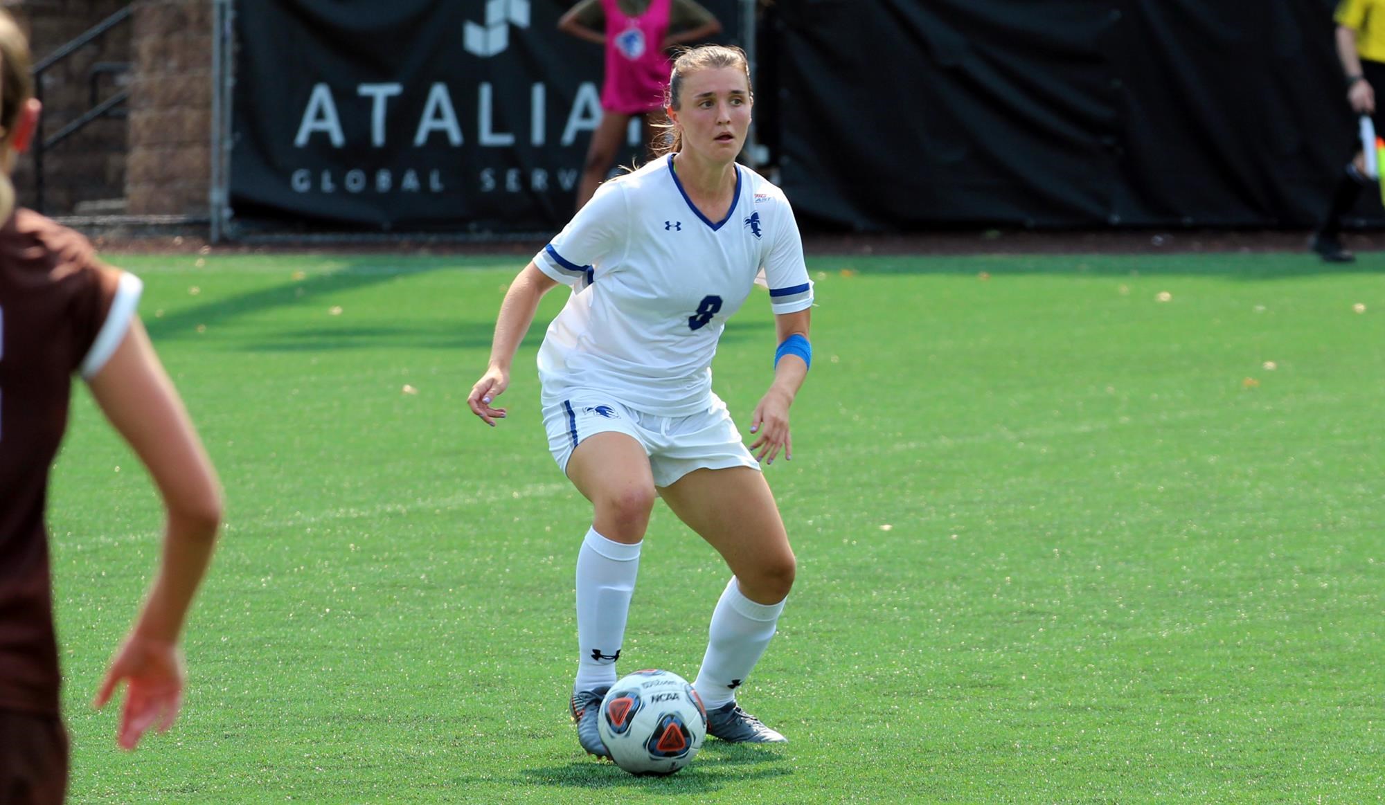 A Seton Hall women's soccer player dribbles the ball on the field during a game.