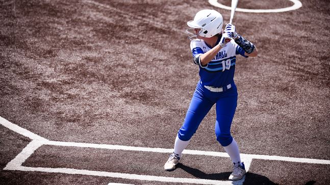 A Seton Hall women's softball player stands in the batter's box waiting for a pitch.