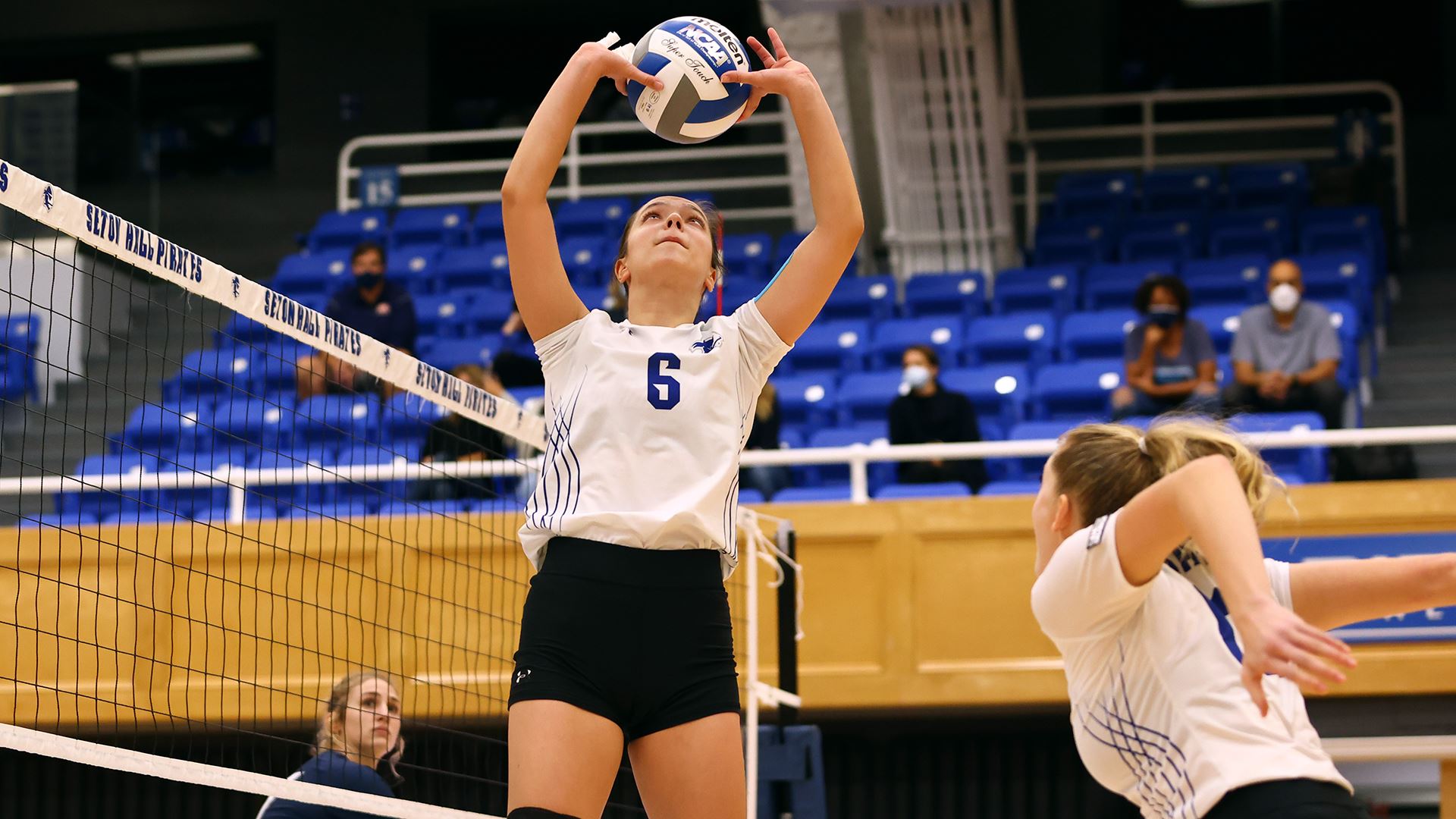 A Seton Hall women's volleyball player sets the ball during a match.