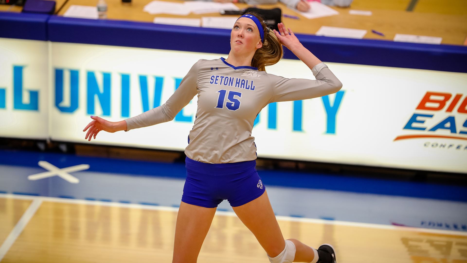 A Seton Hall women's volleyball player tries to spike the ball over the net during a home match.