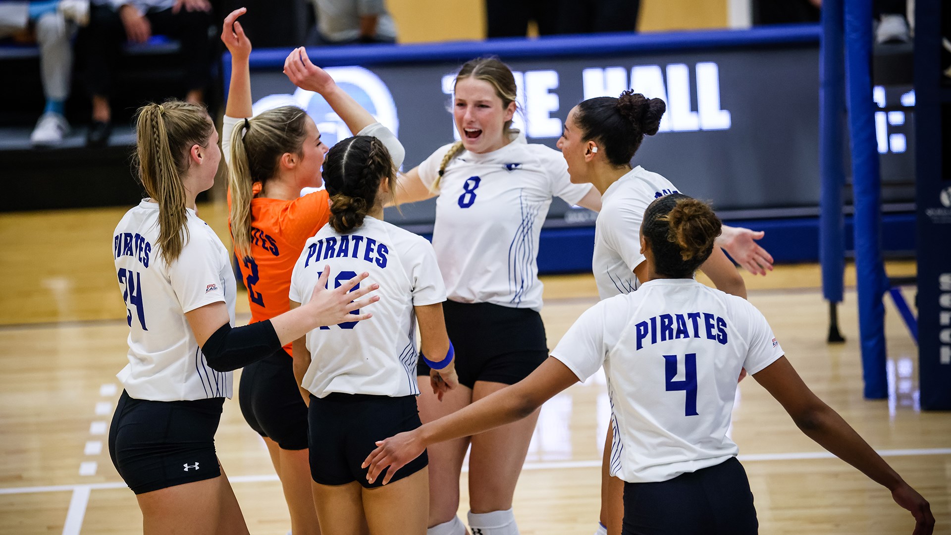 The Seton Hall women's volleyball team celebrates after winning a match during the 2021-22 season.