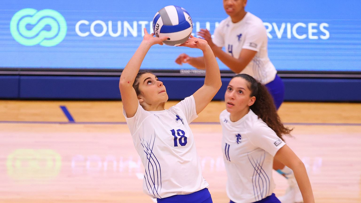 A Seton Hall women's volleyball player hits the ball during a match.