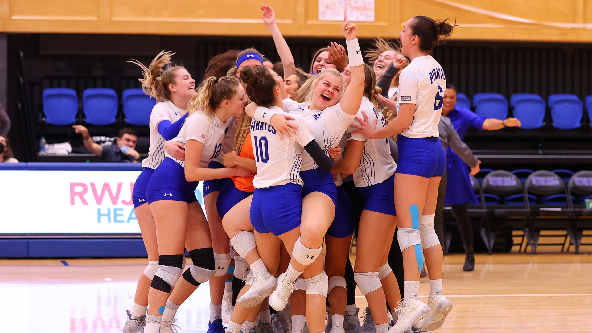 The Seton Hall women's volleyball team celebrates after winning a match against UConn on Senior Night.