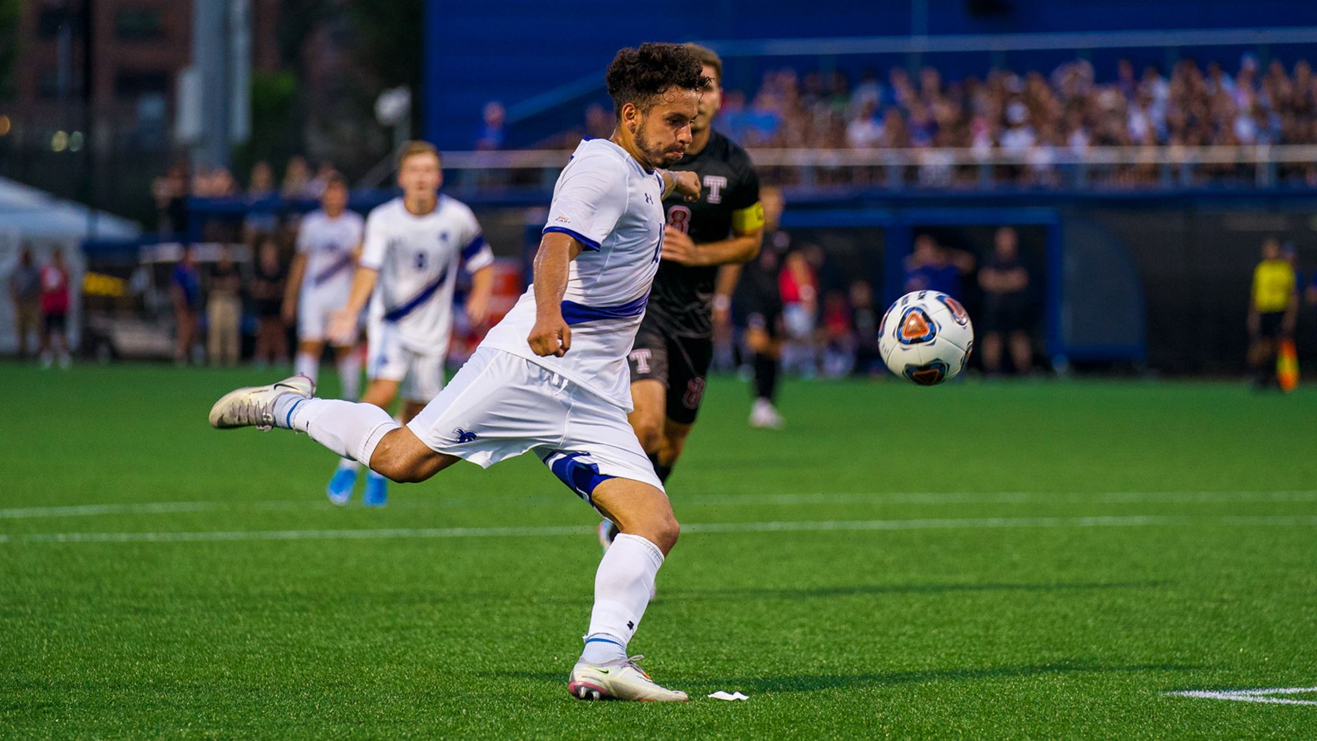 A Seton Hall men's soccer player kicks the soccer ball on offense during a Pirates' home game.