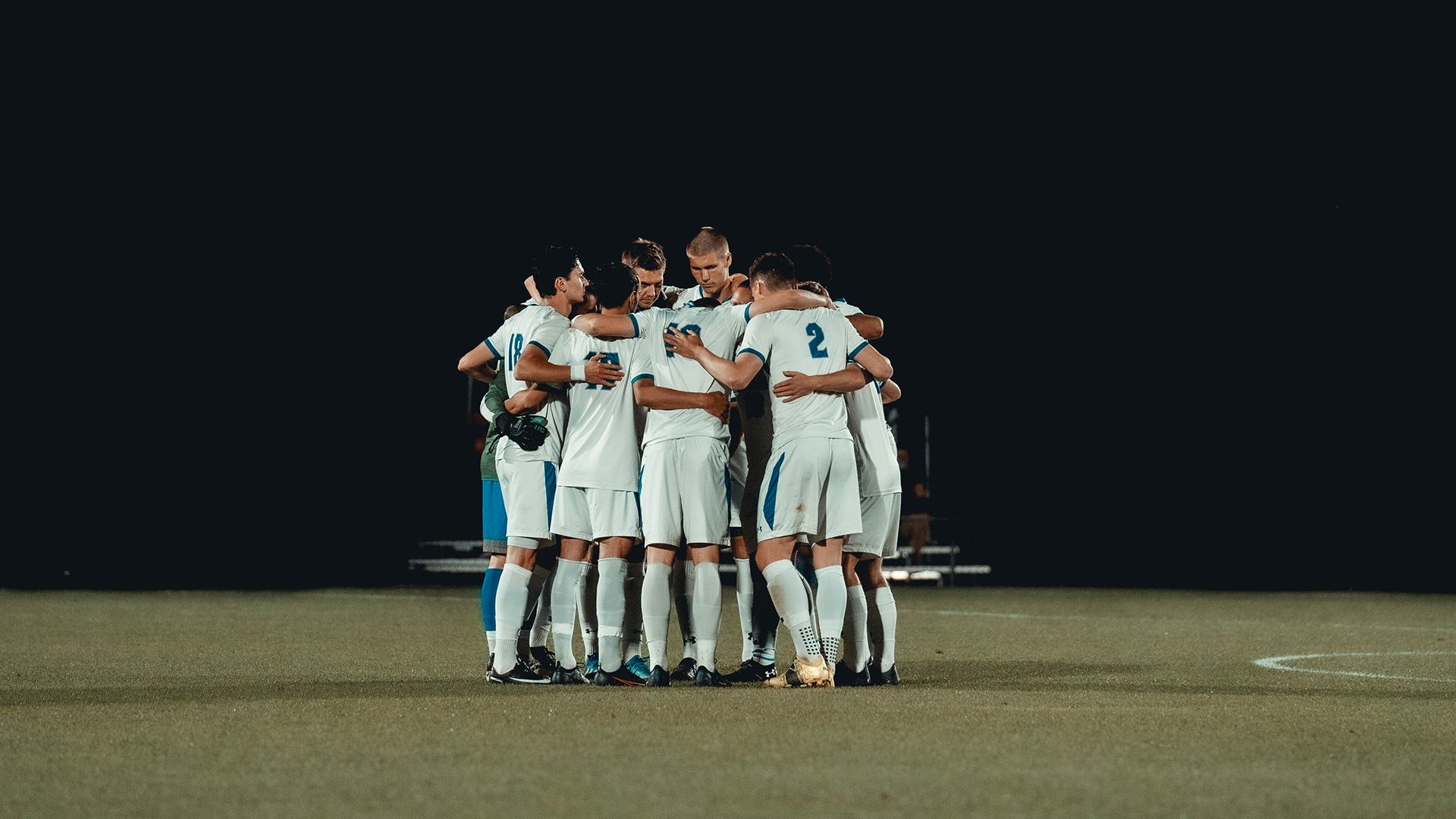 The Seton Hall men's soccer team huddle on the field before an important soccer game.