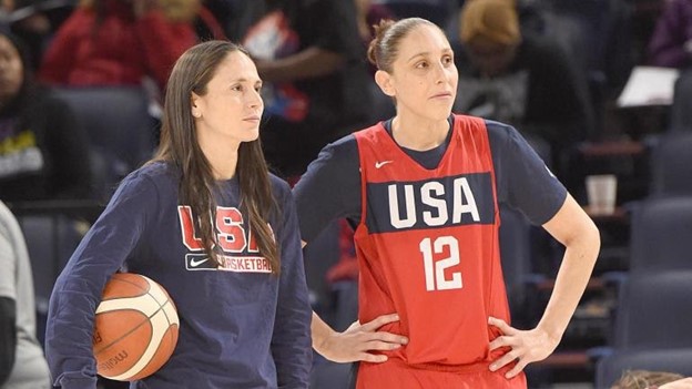 Two USA women's basketball players stand on the practice court in preparation for the 2021 Olympic Games.