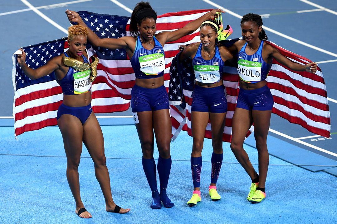 Team USA's women sprinters celebrate with the flag after winning a race.
