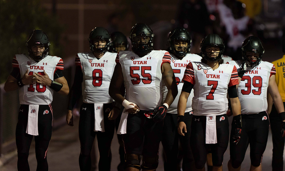 Utah football players stand in a row during a college football game.