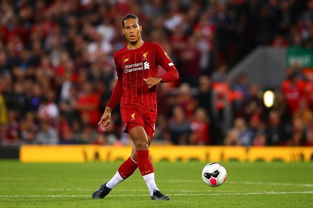 Virgil Van Dijk passes the ball during a soccer game.