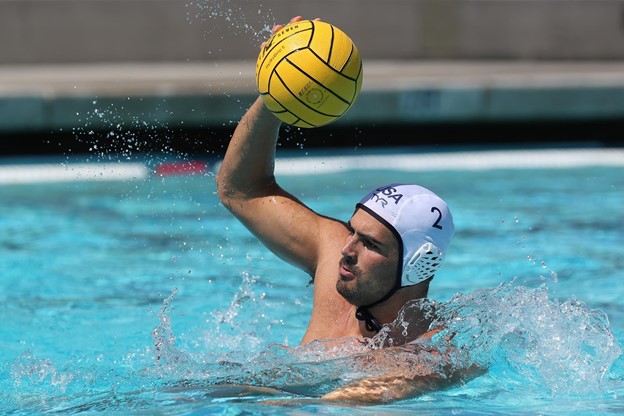 A water polo athlete attempts to throw the ball in a pool during an event.